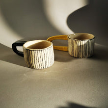 Charger l'image dans la galerie, Magnifique tasse à grande anse jaune, elle pourra vous servir à boire votre thé ou café et pourquoi pas comme objet de déco sur vos étagères. La fonctionnalité des objets de Sabine Orlandini n’est pas immédiate ni définitive. Elle aime que ses objets soient utilisés pour une fonction à laquelle elle n’avais pas pensé. Ses pièces sont montées à la plaque. Elle utilise une terre de faïence blanche lisse ou chamottée, selon les effets et textures recherchés. Elle les engobe, les marque aux crayons oxydes et l